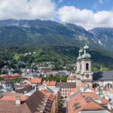 This is a landscape image of the perspective of buildings in Europe. Here we see a view of the terracotta roofs of Europe with the Alps in the background. By Cademix Institute of Technology, Cademix Magazine